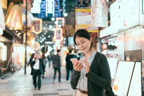 Traveler using cellphone finding dinner. 스톡 사진