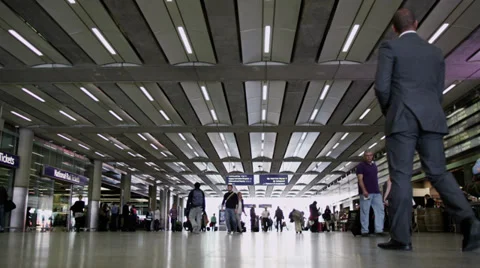 Travelers and commuters passing through London's St. Pancras railway station Stock Footage