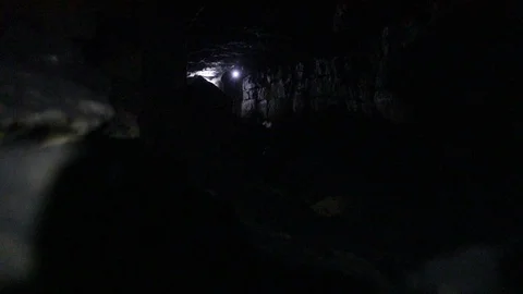 Travelers explore the dark cave Stock Footage 103183198