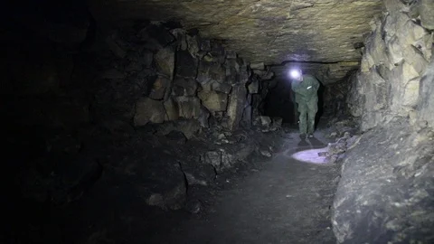 Travelers explore the dark cave Stock Footage 103183335
