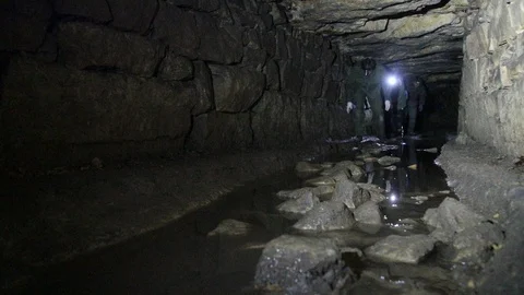 Travelers explore the dark cave Stock Footage 103183406