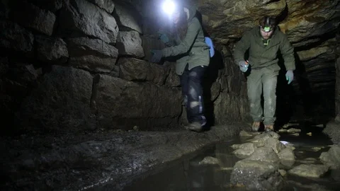 Travelers explore the dark cave Stock Footage 103183455