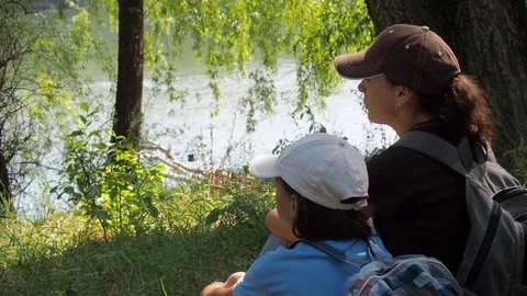 Travelers rest by the water in the forest. Stock Footage