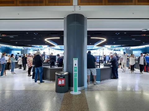 Travelers wait and queue through the security screening checkpoint area 스톡 사진
