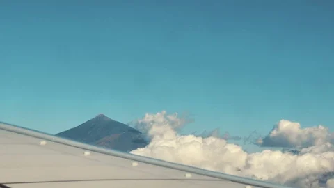 Traveling by air. View of volcano through an airplane window Stock Footage