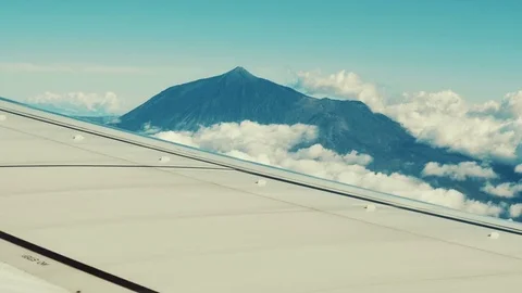 Traveling by air. View of volcano through an airplane window Stock Footage