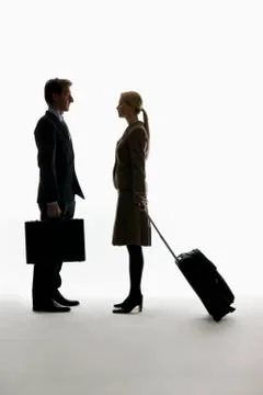 A traveling businessman and businesswoman standing, face to face Stock Photos