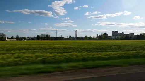 Traveling by car, yellow field on the background of the enterprise Stock Footage 242584253