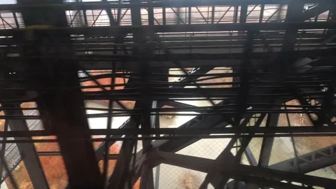 Traveling shot moving beneath a massive metallic bridge Stock Footage 314079416