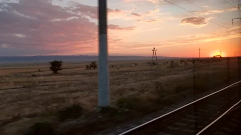 Traveling by train. View out of train of beautiful nature and sunset Stock Footage 161396680