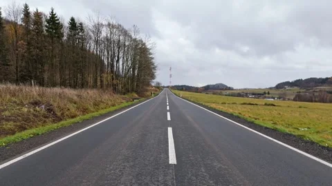 Traveling view down a pristine asphalt road, leading to a cell tower, under.. Stock-Footage 258334621