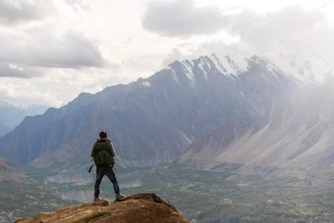 Traveller with backpack walking up the mountain in spring forest Stock Photos