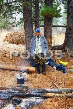 Travellier beside campfires in wood Stock Photos