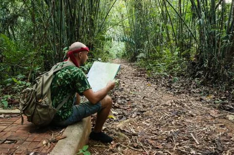 Travelling man sitting and looking at the map in the bamboo forest Stock Photos