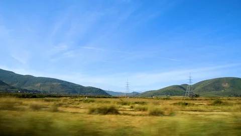 Travelling view from car side window motion blur mountains trees Stock Footage 98733095