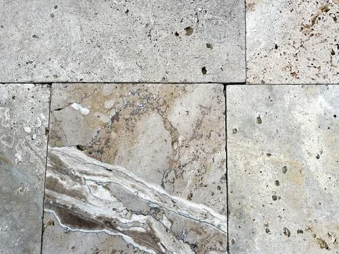Travertine tiles on a deck by a pool. Stock Photos