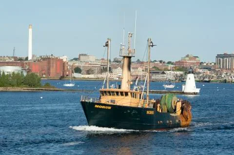 Trawler Morue with lighthouse in background Stock Photos