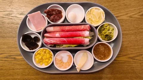 A tray of assorted hot pot side dishes including beef slices, ham, sausage,.. Stockbeeldmateriaal 318268644