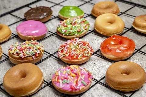 A tray of assorted mini donuts with sprinkles and frosting Stock Photos