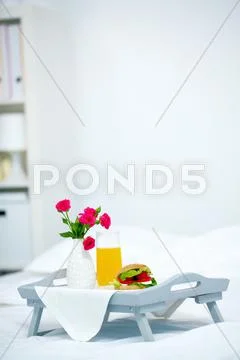 Tray on bed with served light breakfast Stock Photos