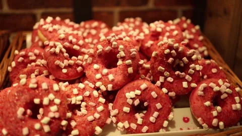 A tray of bright pink donuts topped with mini marshmallows and sugar crystals. T Stock Footage 295673083