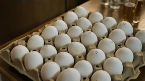 Tray with chicken eggs. Raw eggs in a tray next to shots Stock Footage 273741975