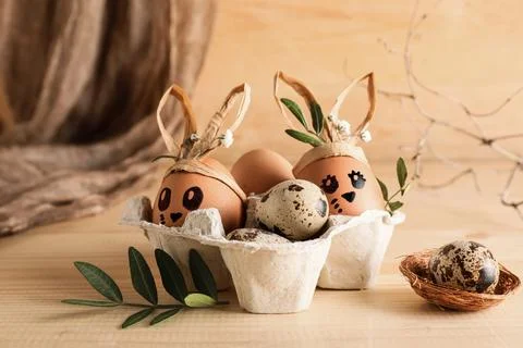 Tray of creative Easter eggs, leaves and flowers on brown wooden background Stock Photos