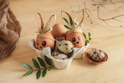 Tray of creative Easter eggs, leaves and flowers on brown wooden background Stock Photos