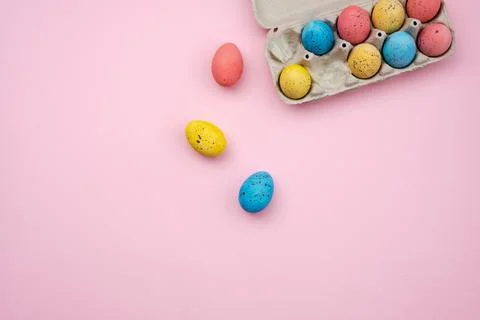 Tray with Easter eggs on pink background. Space for text. Top view. Stock Photos