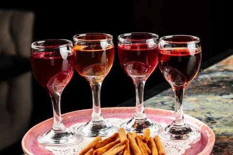 A tray elegantly presenting three small glasses of vibrant red liquid. Foto stock