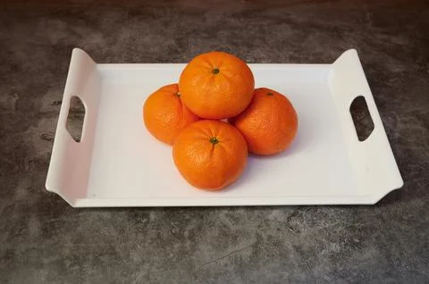 A tray with four oranges on it Stock Photos