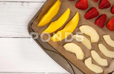 A Tray of Fruit Being Prepared to Dehydrate on a Wooden Table Stock Photos