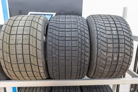 Tread pattern on large rubber speedway tyres in the pit area before a race Foto stock