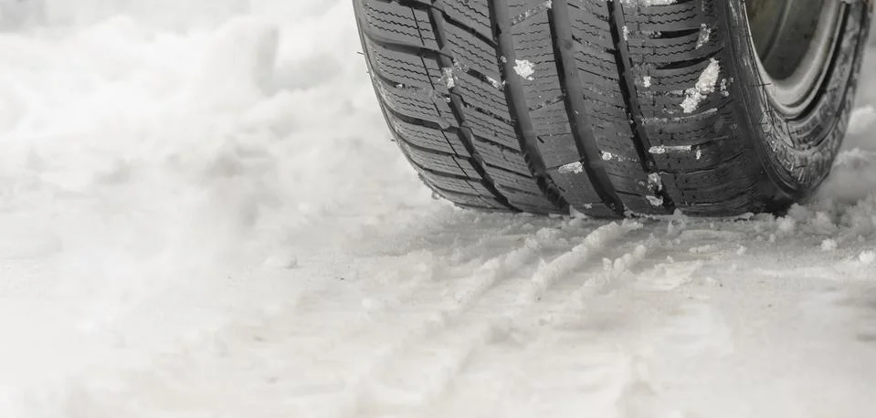 Tread of a winter tire on the snow close up Stock Photos