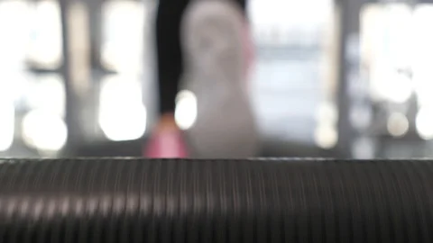 Treadmill movement, man training. close-up. legs of the girl in sneakers go Stock Footage 120540297