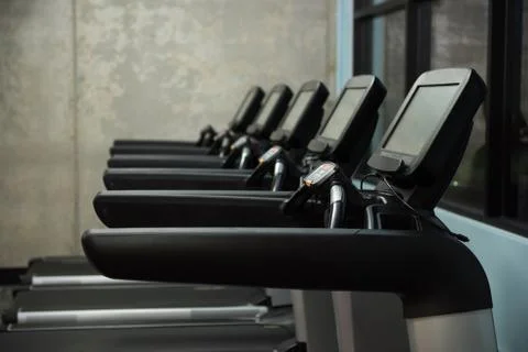 Treadmills in row at empty gym Stock Photos
