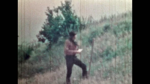 Treasure hunter guarding steps while looking at treasure map on field Stock Footage 279817023