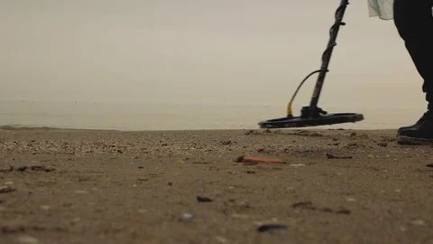 Treasure hunter walking along the sea along the sand with a metal seeker Stock Footage 103140898