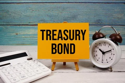 Treasury Bond text written on paper card with calculator and alarm clock on.. Stock Photos