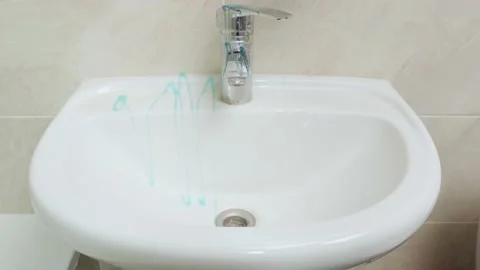 Treating a white sink with blue detergent and disinfectant Stock Footage 168397546