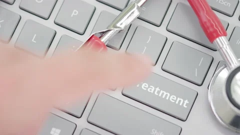 TREATMENT key being pressed on a computer keyboard near stethoscope Stock Footage 137211059
