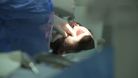 Treatment of lower bicuspid teeth, friendly doctor providing dental services Stock Footage 105571287
