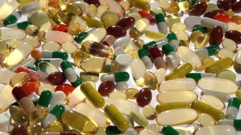 Treatment Many colored capsules, tablets are on the table. Video stock 99579069