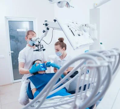 Treatment of root canals under a microscope, work with an assistant. Stock Photos