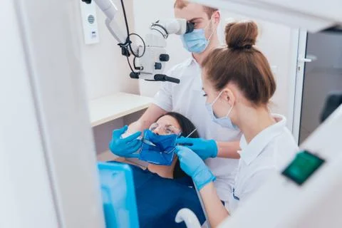 Treatment of root canals under a microscope, work with an assistant. Stock Photos