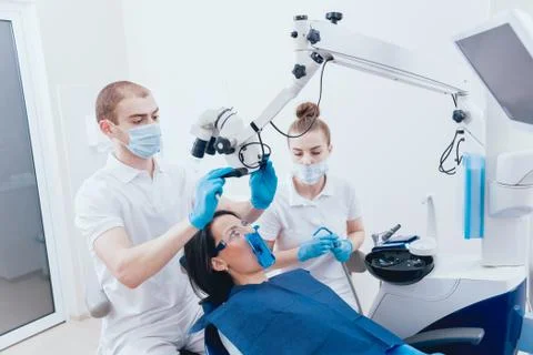 Treatment of root canals under a microscope, work with an assistant. Stock Photos