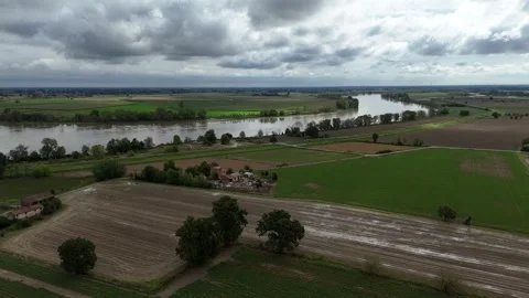 Trebbia River flowing through farmland in Province of Piacenza under dramatic Stock Footage 331058141