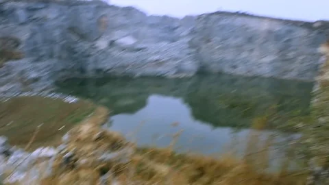 Trecking up a cliff overlooking a lake 库存影片 100642583