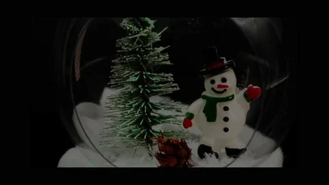 Tree and snowman inside a glass ball with shimmering lights in different colors Stock Footage 166372813