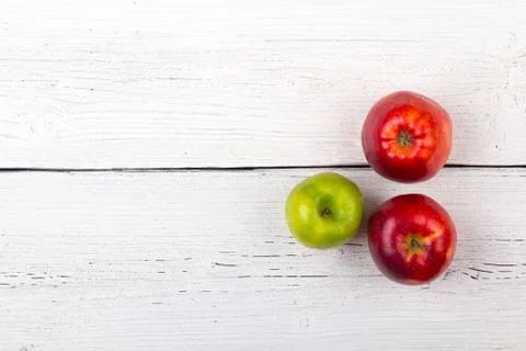 Tree apples on a white wooden surface. Stock Photos
